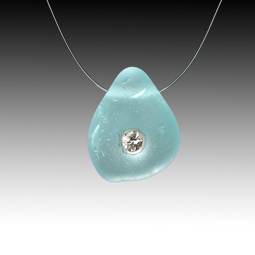 A 10 pt diamond is delicately set into this genuine piece of aqua sea glass. The glass then 'floats' on a barely there invisible chain!