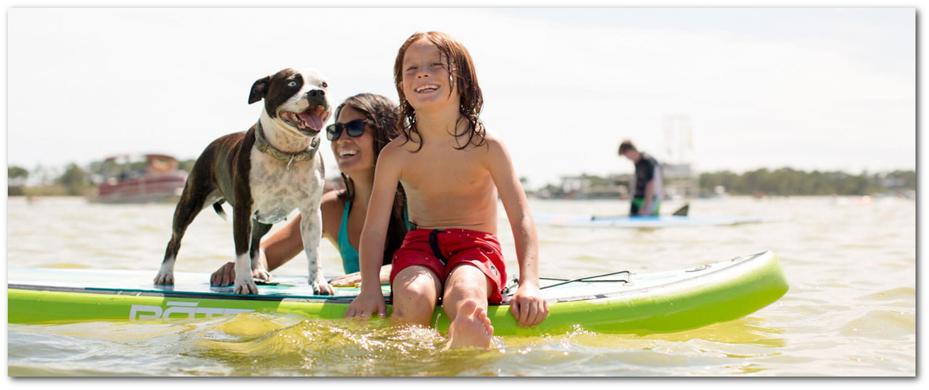 Mother and son enjoy their stand up paddle board rental with their dog