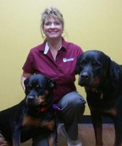 Lisa Mcdonald kneeling with 2 dogs